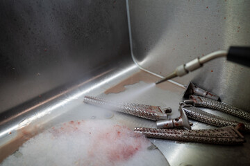 some bloody cutters are cleaned with a high pressure cleaner after an operation