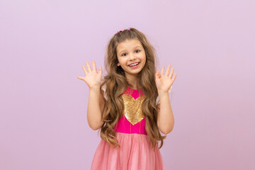 A little beautiful girl with curly hair. A girl in a pink dress.