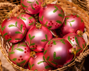 Pink Christmas balls in a wicker basket as background.