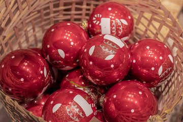 Red Christmas balls in a wicker basket as background.