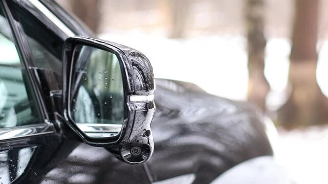 The side-view camera is installed in the side mirror of a black car. 360 degree all-round cameras. New technologies. Modern technologies in the car.