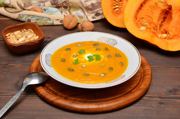 still life in rustic style pumpkin soup and pumpkin fruits nearby