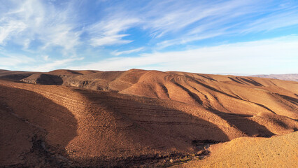 Fototapeta na wymiar Panorama of hills with regular brown soil pattern in Tizi'n-Tinififft pass Ouaourmas Morocco, blue sky above