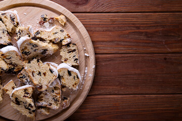 Obraz na płótnie Canvas Dresdner Stollen is a Traditional German Cake with raisins on wooden background with place for text. Fruit cake for the Holiday.