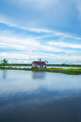 An Old  Farmhouse Surrounded by a backwaters, backwaters photography during daytime under blue sky, Kerala backwaters Kadamakkudy Kerala