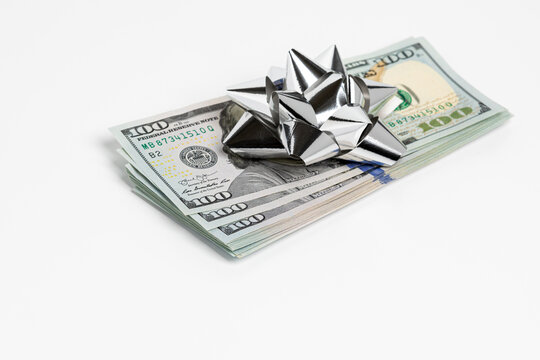 Cash Gift Of 100 Dollar Bills With Silver Bow. Gift Tax, Charitable Donation And Holiday Present Concept.