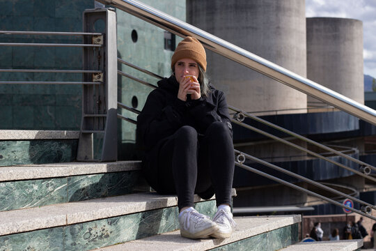 Cold Blue Haired Woman Drinking Coffee On The Stairs.