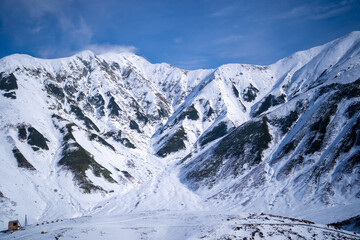 Fototapeta premium 富山県立山町にある立山の冬の雪景色のある風景 Landscape with snowy winter scenery of Tateyama in Tateyama Town, Toyama Prefecture, Japan.