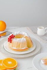 Orange cake with decorated red berries, orange slices. Morning homemade breakfast. Daylight. White background.on a marble background