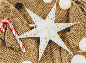 Brown knitted sweater and garlands, led lights. Women fashion winter clothes and accessories. New year and Christmas celebration mockup. Christmas background with stars
