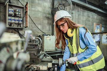 A female engineer in a white helmet inspects the equipment and double-checks the security system's configuration. 