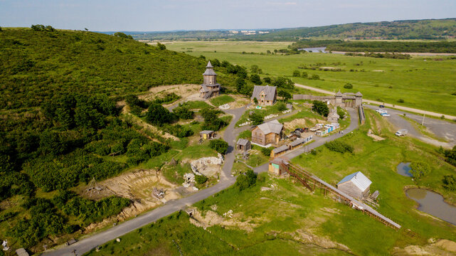 Old Russian peasant settlement in the summer. View from above. Slavic village in the field.