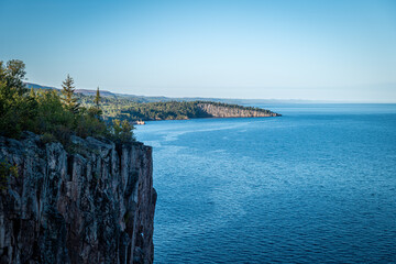 Beautiful landscape along the north shore of Lake Superior in Minnesota, from Palisade Head, a natural sheer cliff at the edge of the blue water. Evening image at the shore of Gitchi-Gami. - obrazy, fototapety, plakaty