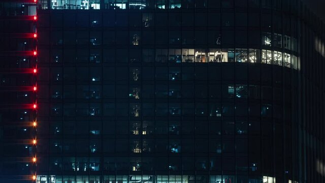 Time lapse modern glass business center windows lights turned off after working day, blinking office windows light building facade, people working late night. Corporate, skyscraper surface. End of day