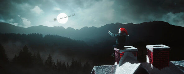 child surprised to see Santa Claus above the fireplace on beautiful Christmas night under moonlight