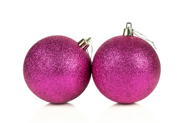 Two magenta glittered Christmas balls isolated on white background with reflection