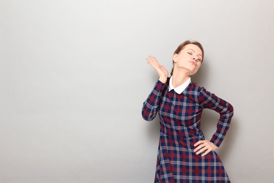 Shot of funny young blond woman making flirtatious grimaces and posing