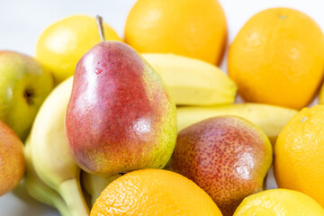 Close-up group of various fruits - pears, bananas, lemon and oranges. Ripe bright fruits - sources of vitamins and antioxidants. Healthy food