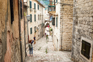 Stone streets of the old town of Kotor. Montenegro, Balkans. Ancient Roman houses. Tourists. Summer.