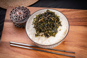 The seaweed seasoned laver anchovy with shrimp flavor sprinkled on rice on wooden background.