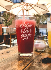 Big glass of natural strawberry juice with the message 'elige tu viaje' (choose your journey) 
