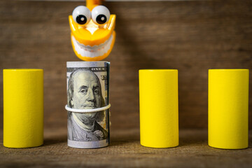 Plastic toy teeth with a roll of dollar banknote.