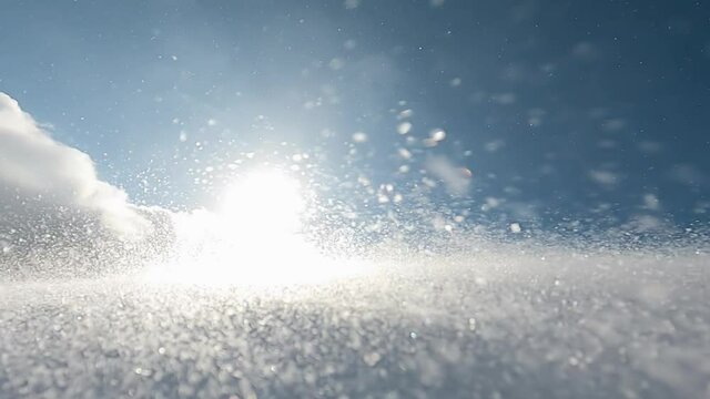Snow drift flying through the air on the winter mountain slope because of the heavy snow storm, closeup and slow motion