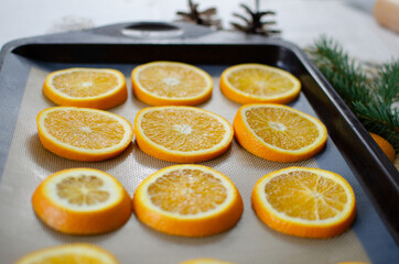 Naklejka na ściany i meble Oranges on a baking tray getting ready to be transformed into homemade Christmas ornaments