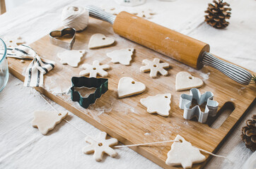 Fototapeta na wymiar White, salt dough, homemade Christmas tree ornaments in the shape of trees, hearts and snowflakes.