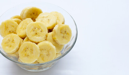 Banana slices in glass bowl on white  background.