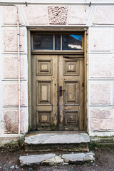 Fototapeta na wymiar Historic stone house with old wooden doors and windows at the top. Kuldiga, Latvia