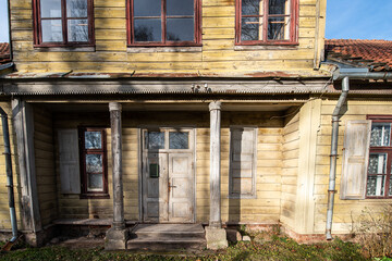 Historical wooden house with old wooden doors, wood carvings and columns. Kuldiga, Latvia