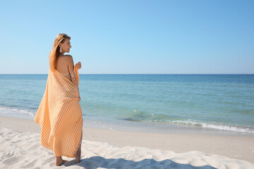 Fototapeta na wymiar Woman with beach towel near sea on sunny day