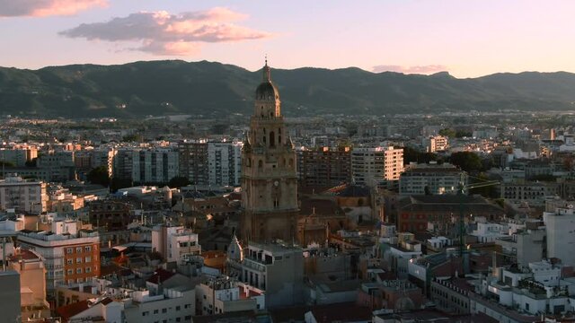 Close up aerial shot of Murcia Cathedral in Spain. Mountain cityscape view