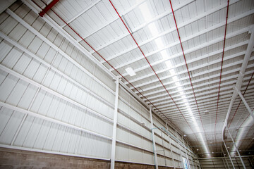 Roller door or roller shutter inside factory, warehouse or industrial building. Modern interior design with polished concrete floor and empty space for product display or industry background