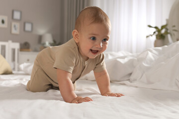 Cute baby crawling on bed at home