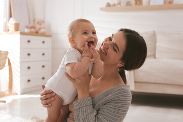 Happy young mother with her cute baby at home - obrazy, fototapety, plakaty