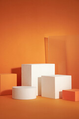 Front view of white and orange podium with orange tree in a orange background for advertising ,...