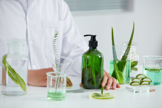 Aloe vera extract in laboratory , petri dish in a white background , green leaf  in a test tube and doctor for cosmetic jar advertising , photography science concept