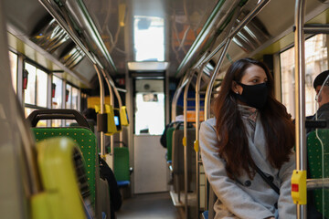 Fototapeta na wymiar Woman with a respiratory mask is travelling by bus due to a coronavirus pandemic