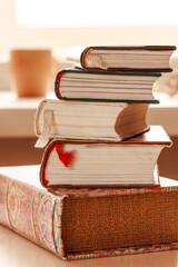 Pile of books, stack of books on the table in the room, library or office. Close up