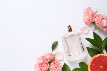 Composition with bottle of perfume and fresh citrus fruit on white background, top view. Space for...