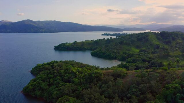Sunrise Over Presa De Hatillo (Hatillo Dam) Surrounded By Lush Green Forested Hills In Sanchez Ramirez Province, Dominican Republic. wide aerial