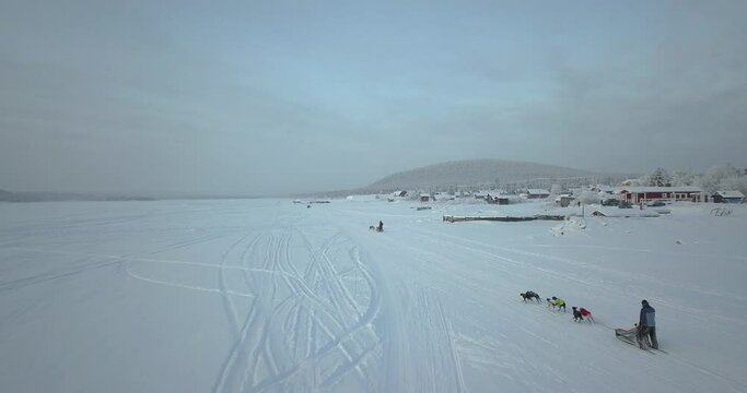 Dog Sledding - Musher Riding A Dog Sled ON A Snowy Field During Winter In Kiruna, Sweden. - aerial
