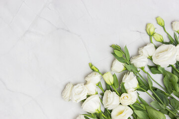 A bouquet of white roses on light marble background. 