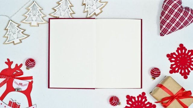 Opened book for text and cute decorations for Christmas on white theme. Stop motion