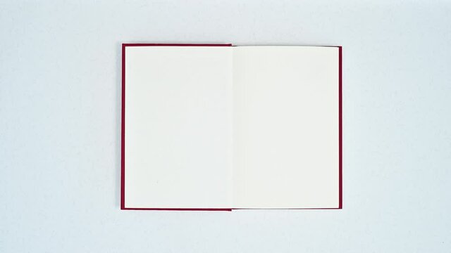 Woman hand open red book on white theme. Stop motion