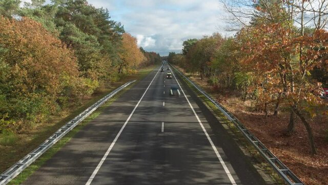 Traffic In Daylight At The A28 Highway In Gelderland, the Netherlands With Autumnal Trees. high angle, time lapse