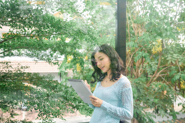 Creative woman standing on porch and writing thoughts and affirmations in her diary