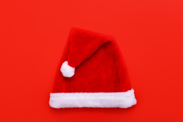 Obraz na płótnie Canvas Santas hat on red christmas background with copy space for text.
